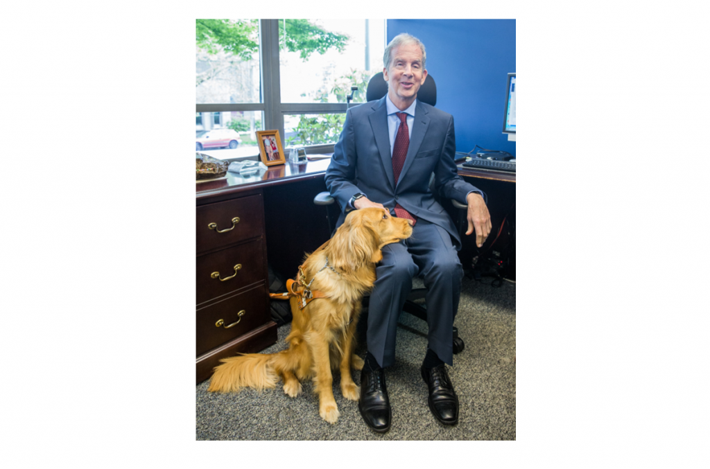 Mike May with guide dog Jonnie in his office