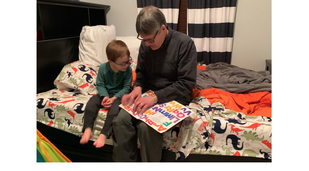Pete reading a print-braille book to our grandson