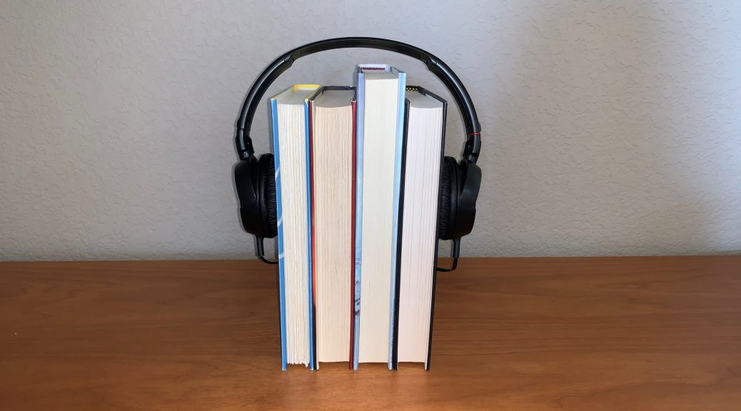 Four books standing up wearing headphones as if they were a head